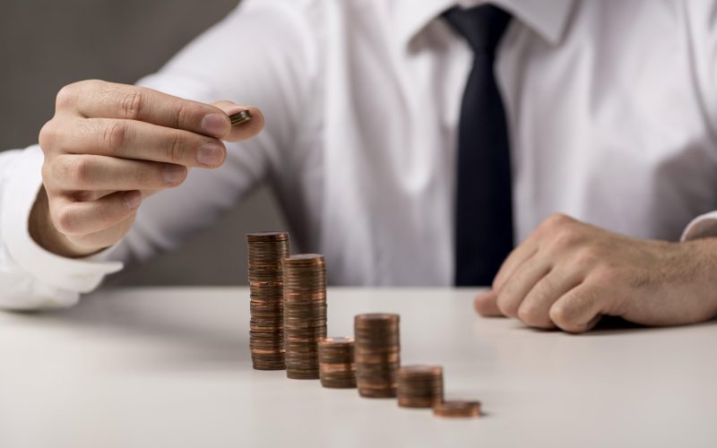 businessman-adding-coin-stack